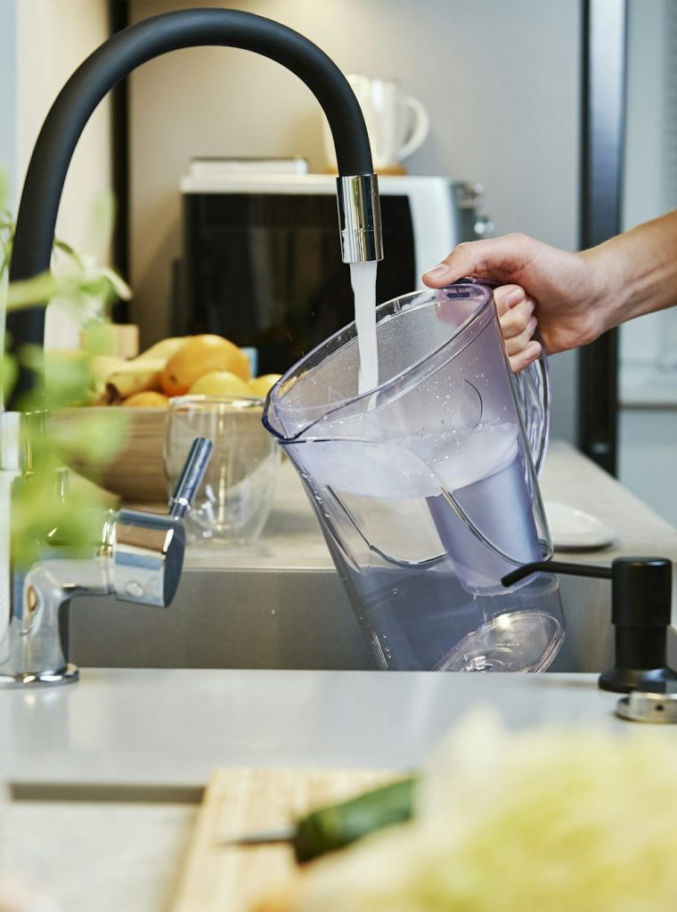 Woman pouring water filter jag